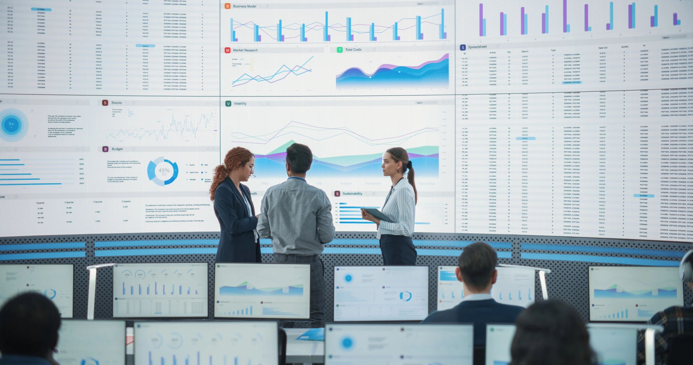 Team reviewing data on a large monitoring screen